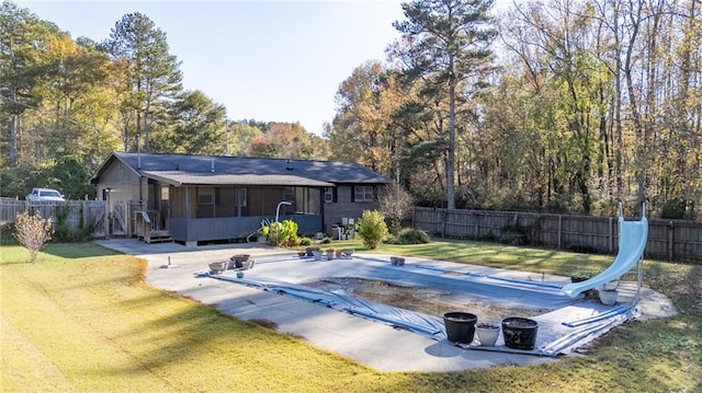 view of swimming pool featuring a water slide, a lawn, a sunroom, and a patio