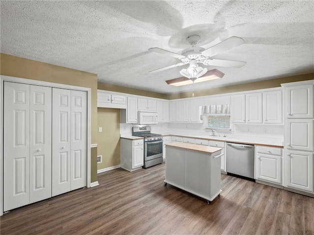 4654 Fox Forrest Dr, Flowery Branch, GA 30542 - kitchen with stainless steel appliances, white cabinets, dark wood-style floors, a sink, and a textured ceiling