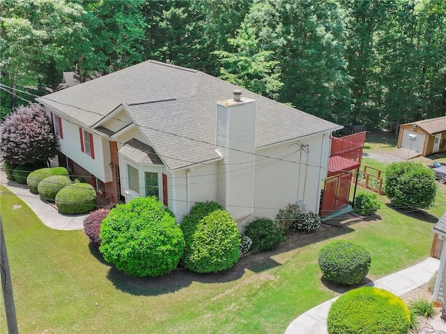 4654 Fox Forrest Dr, Flowery Branch, GA 30542 - view of side of home featuring roof with shingles and a chimney