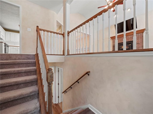 4654 Fox Forrest Dr, Flowery Branch, GA 30542 - staircase with a ceiling fan, wood finished floors, and a fireplace