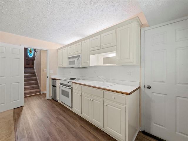 4654 Fox Forrest Dr, Flowery Branch, GA 30542 - kitchen featuring white appliances, a sink, dark wood-style floors, a textured ceiling, and light countertops
