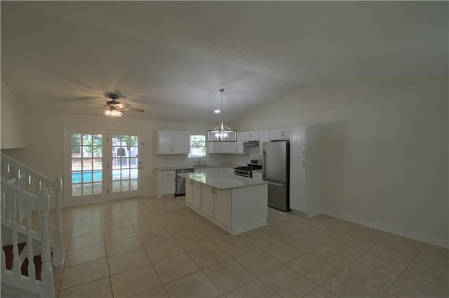 kitchen featuring a center island, ceiling fan with notable chandelier, white cabinetry, vaulted ceiling, and appliances with stainless steel finishes