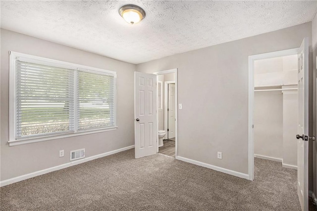 637 Carlouetta Rd SW, Mableton, GA 30126 - unfurnished bedroom featuring carpet, a spacious closet, a textured ceiling, and a closet