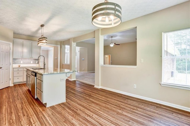 501 Barhams Ridge Dr, Mcdonough, GA 30252 - kitchen with an island with sink, wood finished floors, dishwasher, a sink, and baseboards