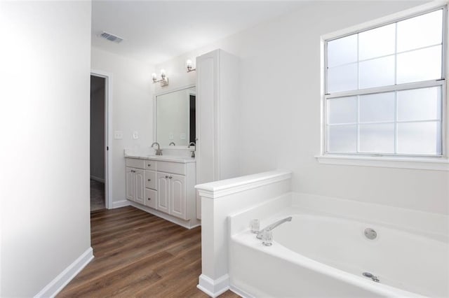 bathroom featuring vanity, a washtub, and hardwood / wood-style flooring