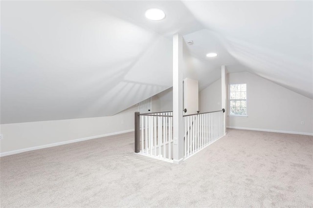 bonus room featuring lofted ceiling and light colored carpet