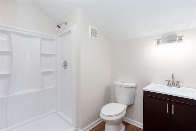 bathroom with toilet, vaulted ceiling, walk in shower, wood-type flooring, and vanity