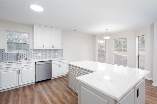 kitchen featuring sink, decorative light fixtures, white cabinetry, dishwasher, and a kitchen island