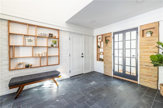 interior space featuring french doors and brick wall