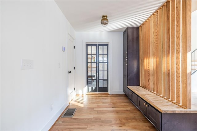 mudroom with light hardwood / wood-style floors and french doors