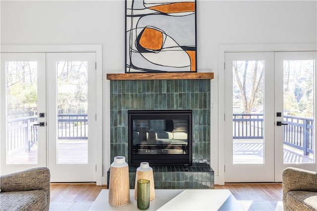 entryway with a tile fireplace, french doors, and light hardwood / wood-style floors