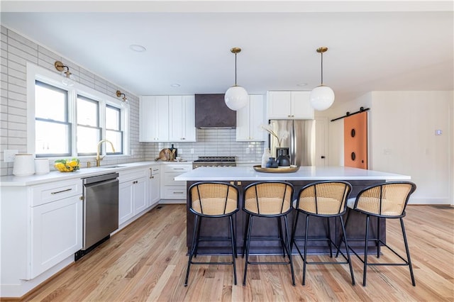 kitchen with pendant lighting, a center island, white cabinetry, and stainless steel appliances