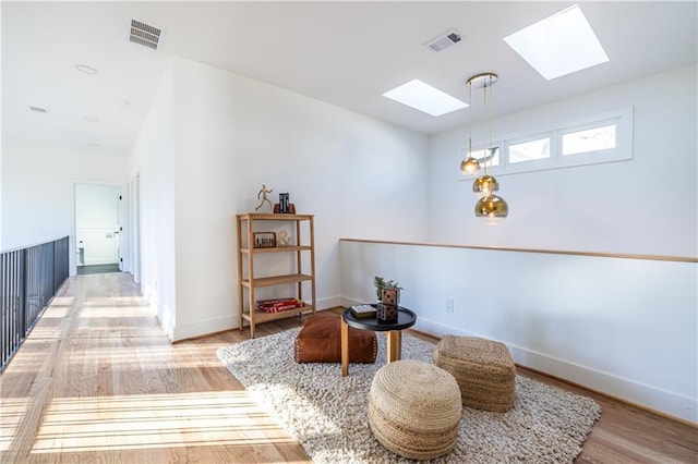 living area featuring hardwood / wood-style floors and a skylight