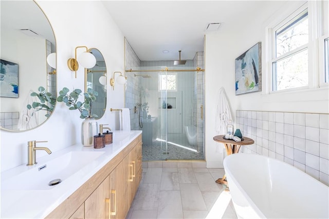 bathroom with vanity and shower with separate bathtub