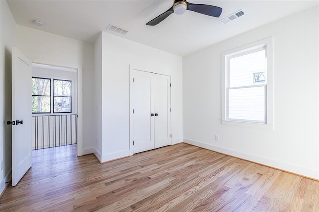 unfurnished bedroom with ceiling fan, a closet, and light hardwood / wood-style floors