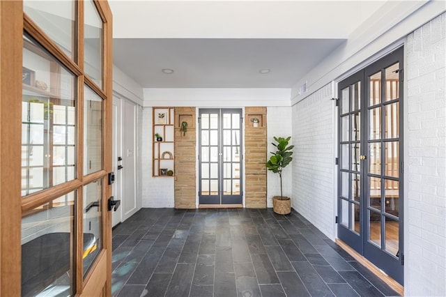 doorway to outside with french doors and brick wall