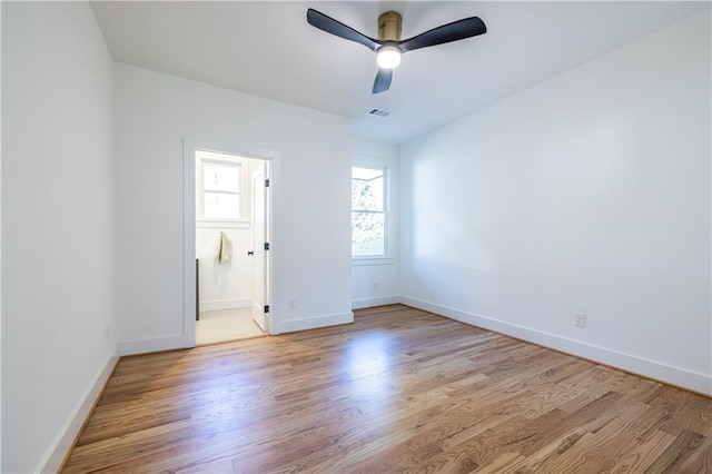 unfurnished bedroom with ensuite bathroom, ceiling fan, and light hardwood / wood-style floors