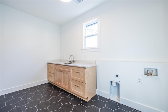 clothes washing area with hookup for a washing machine, sink, cabinets, and hookup for an electric dryer