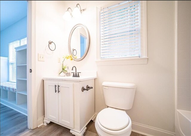 full bath featuring wood finished floors, toilet, plenty of natural light, and baseboards