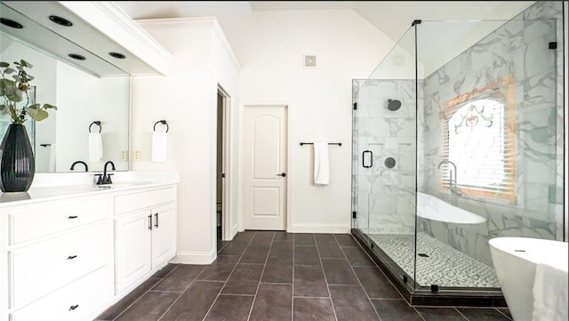 full bathroom featuring a marble finish shower, vanity, baseboards, a freestanding tub, and lofted ceiling