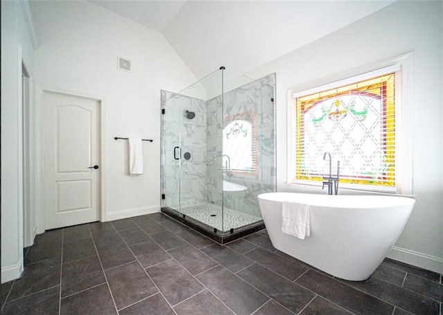 full bath with a marble finish shower, a freestanding tub, vaulted ceiling, and baseboards