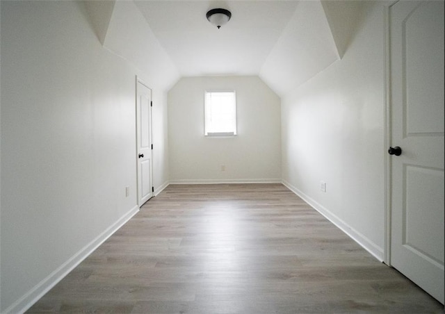 bonus room featuring lofted ceiling, wood finished floors, and baseboards