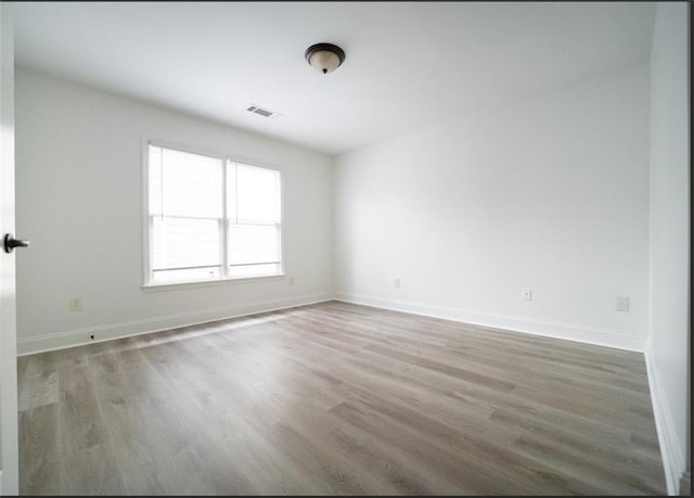 empty room with wood finished floors and baseboards
