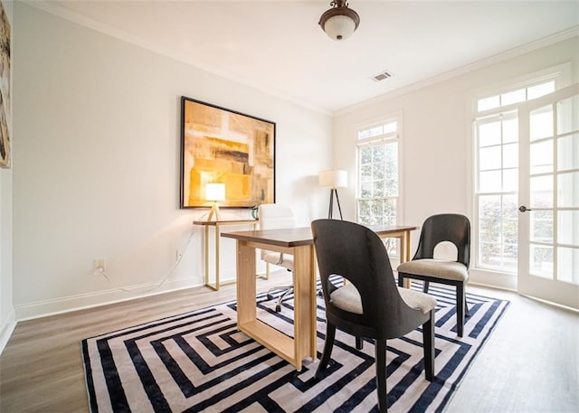 office space featuring wood finished floors, baseboards, and ornamental molding