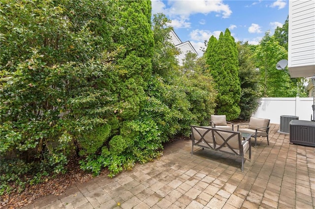 view of patio / terrace featuring an outdoor living space, central AC unit, and fence