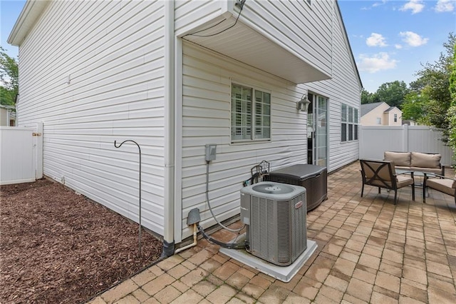 view of patio / terrace featuring an outdoor living space, central AC unit, and fence