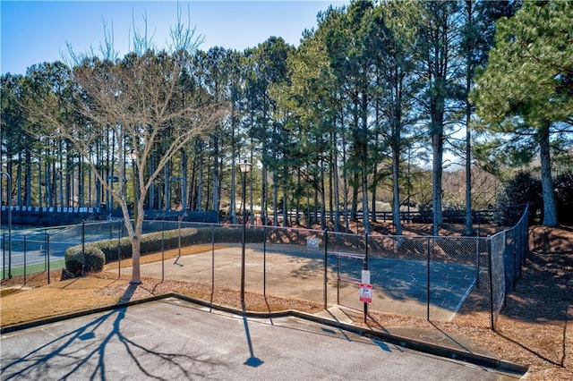 surrounding community with fence and view of scattered trees
