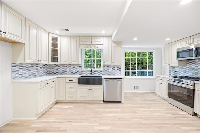 1172 Colony Dr, Marietta, GA 30068 - kitchen featuring appliances with stainless steel finishes, tasteful backsplash, light countertops, light wood-style floors, and recessed lighting