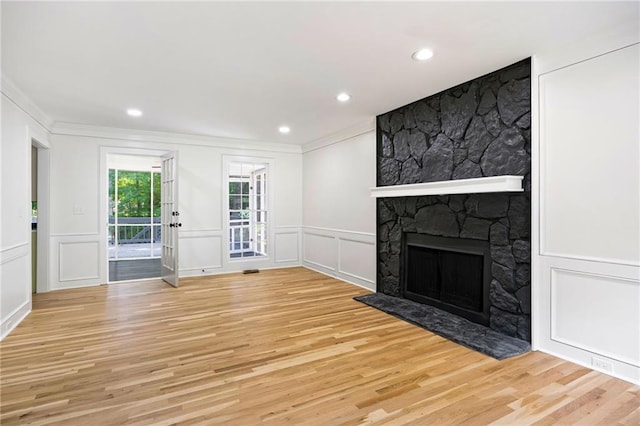 1172 Colony Dr, Marietta, GA 30068 - unfurnished living room featuring crown molding, a decorative wall, light wood-type flooring, a stone fireplace, and recessed lighting