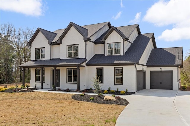 view of front of property with brick siding, concrete driveway, an attached garage, covered porch, and a front yard