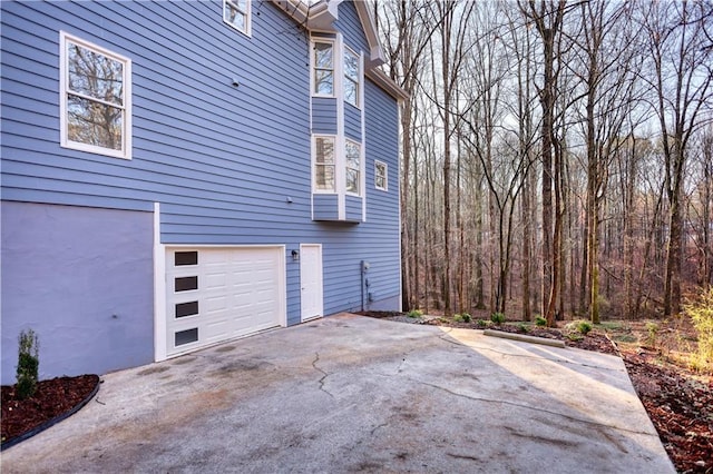 view of home's exterior with an attached garage and driveway