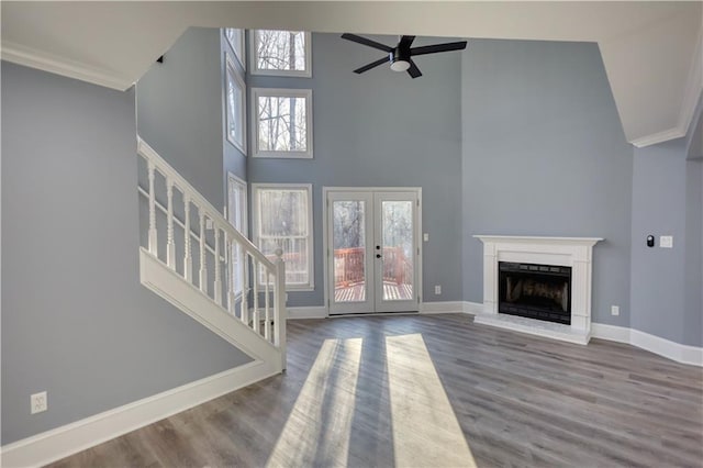 unfurnished living room featuring baseboards, a fireplace with raised hearth, and crown molding