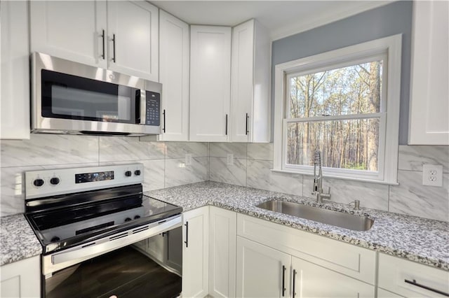 kitchen featuring a sink, stainless steel appliances, white cabinets, and decorative backsplash