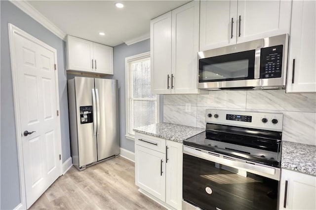 kitchen with decorative backsplash, light stone countertops, appliances with stainless steel finishes, and white cabinetry