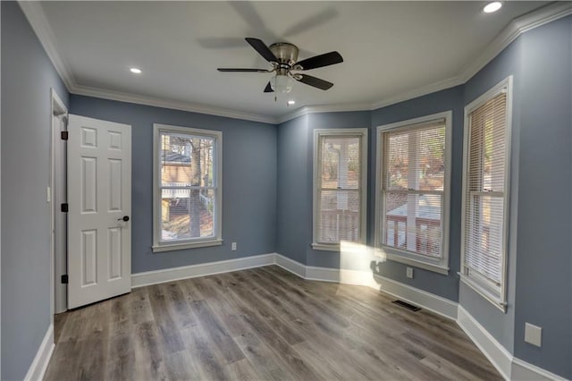 spare room featuring wood finished floors, baseboards, and ornamental molding