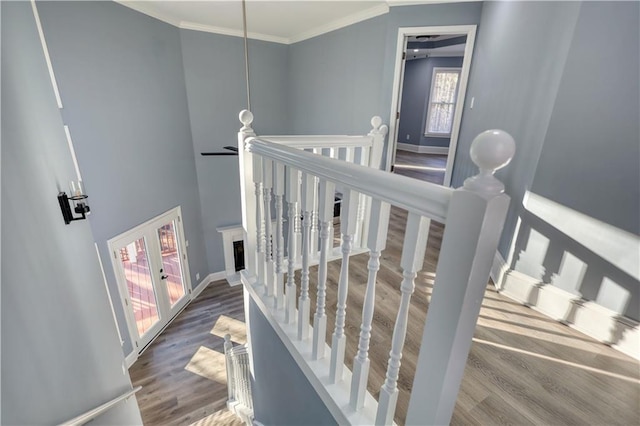 staircase featuring baseboards, wood finished floors, a ceiling fan, and ornamental molding