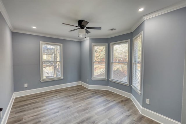 unfurnished room featuring wood finished floors, baseboards, and ornamental molding