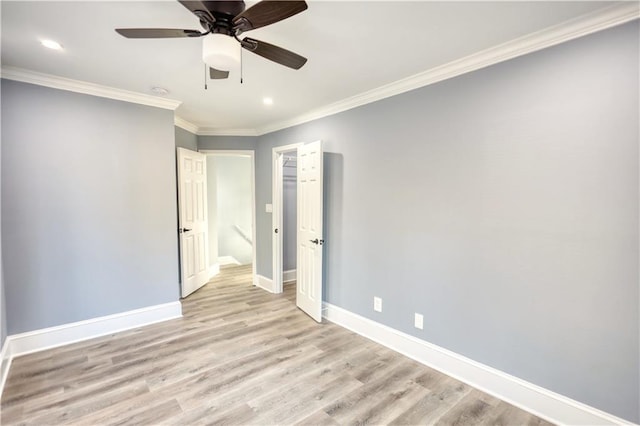 unfurnished room featuring baseboards, a ceiling fan, light wood-style flooring, and crown molding