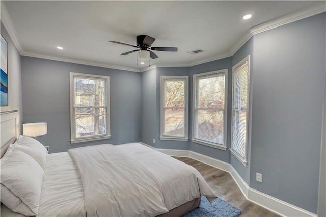 bedroom featuring baseboards, wood finished floors, and ornamental molding