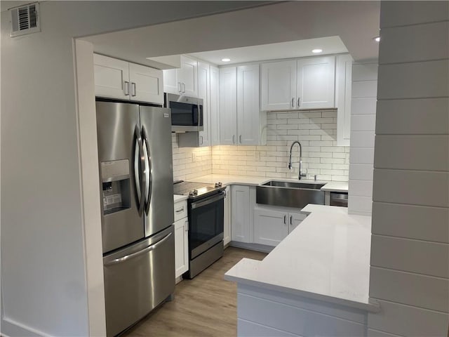 145 Amherst Pl NW, Atlanta, GA 30327 - kitchen featuring visible vents, light countertops, white cabinets, a sink, and appliances with stainless steel finishes