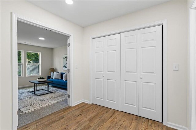 unfurnished bedroom featuring a closet, baseboards, and wood finished floors