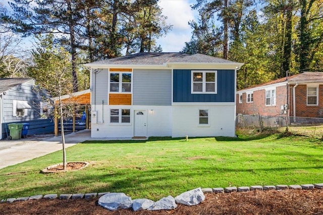 view of front facade featuring fence, board and batten siding, and a front yard