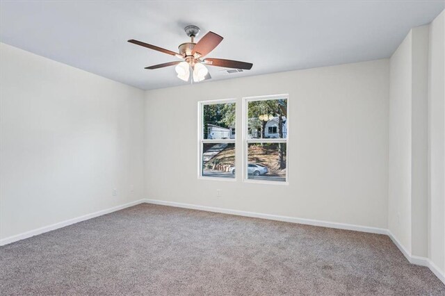 spare room with carpet, baseboards, and ceiling fan