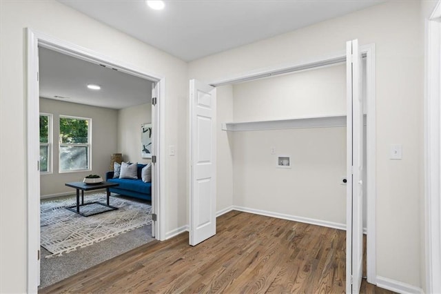 washroom with washer hookup, laundry area, baseboards, and wood finished floors