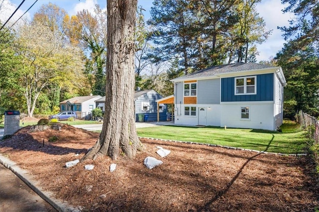 view of front of property featuring fence, a front lawn, and board and batten siding