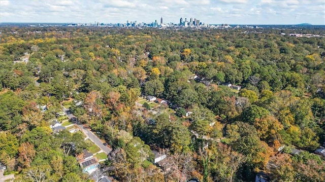 drone / aerial view featuring a city view and a forest view